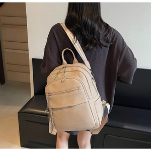 Beige faux leather backpack featuring textured finish and patterned jacquard straps