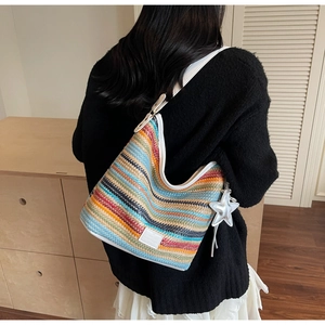 Detalle del bolso de hombro tejido multicolor con colgante de estrella y rayas
