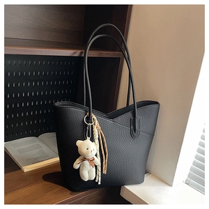 Detailansicht schwarzer Shopper aus Narbenleder mit Bärenanhänger und Quasten