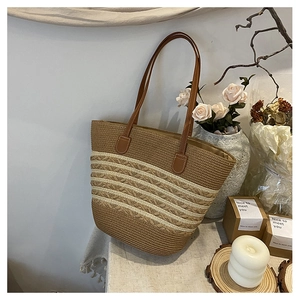 Close-up of woven tote bag texture with brown leather straps and striped pattern