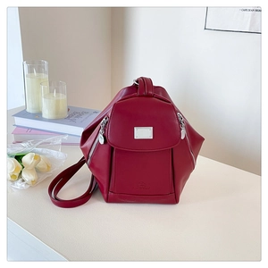 Macro detail of dark red PU leather backpack featuring silver hardware and magnetic closure
