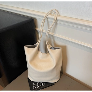 Close-up of cream lychee texture leather tote bag with soft bucket design and slim strap
