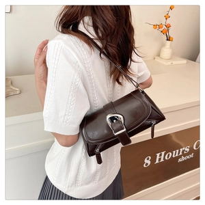 Close-up of a dark brown soft leather bag featuring a wide belt buckle and silver buckle