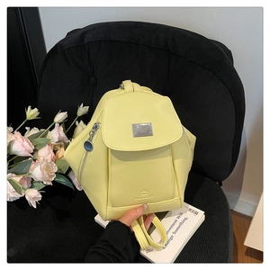 Detailed macro view of yellow geometric PU leather backpack with silver metal brand logo