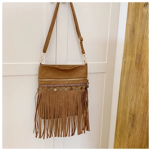 Détail du sac bandoulière en suédine marron avec de longues franges et broderies ethniques