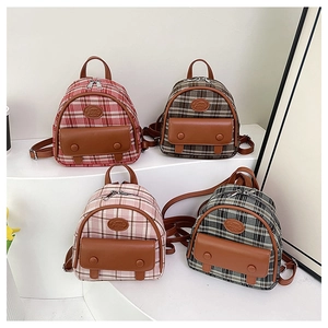 Detail view of mini checkered backpacks in four colors with faux leather trim