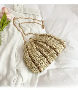 Détail du sac de plage en paille tressée avec motif rayé, chaîne dorée et fermoir vintage
