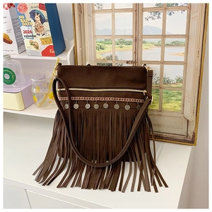 Détail du sac bandoulière bohème marron foncé avec broderies ethniques et longues franges