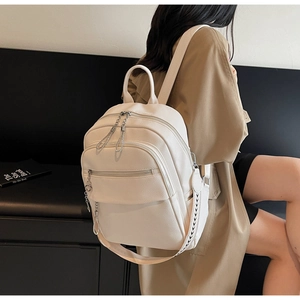Detail view of cream white textured leather backpack with geometric pattern straps