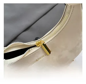 Détail de la fermeture éclair dorée et de la chaîne sur le sac à main crème chic