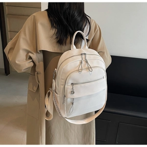 Detailed back view of white lychee-textured backpack with multiple zipper pockets