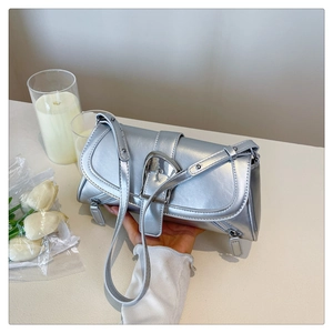 Detail of silver metallic baguette bag featuring a large horseshoe buckle and smooth finish