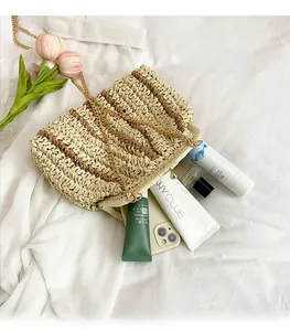 Détail montrant l'intérieur spacieux du sac à bandoulière en paille rayé avec chaîne