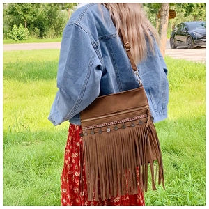 Détail du sac bohème vintage en daim marron avec tissage ethnique et franges