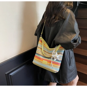 Detalle del bolso hobo de punto a rayas de colores con correa verde y colgante de estrella