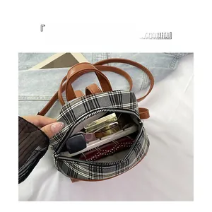 Internal view of mini plaid backpack showing storage for phone, lipstick, and cosmetics