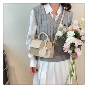 Sac bandoulière chic beige et kaki porté avec une tenue de printemps et fleurs