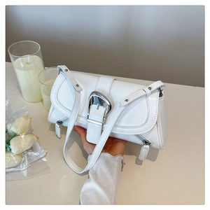 Detailed close-up of white soft leather handbag with oversized silver metal buckle