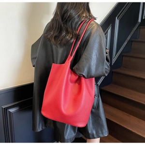 Detailed view of red leather bridal tote bag featuring lychee texture and round shoulder straps
