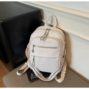 Detail of white lychee leather backpack with stylish striped straps and silver zippers