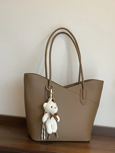 Braune Tote Bag aus Leder mit gewelltem Rand und Plüschbär-Anhänger für Damen