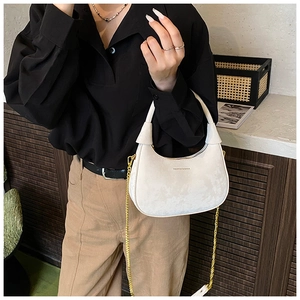 Détail du sac demi-lune blanc avec bandoulière chaîne dorée et lettrage de marque élégant