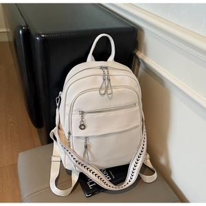 Detail of cream backpack with pebble grain leather and woven geometric shoulder strap