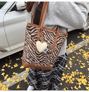 Détail du sac cabas en laine zébré avec breloque cœur et poignée en cuir premium