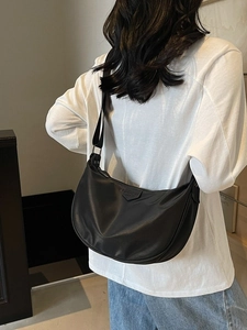 Minimalist black hobo shoulder bag with adjustable strap and iconic triangle logo patch