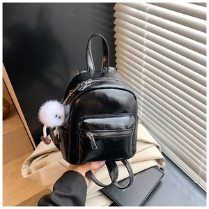 Mini black glossy leather backpack with a cute white plush monster pendant detail
