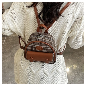 Rear view of model wearing a vintage mini plaid backpack with brown faux leather details