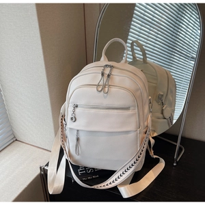 Detail of off-white lychee texture backpack with metallic zippers and geometric strap