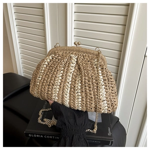 Dettaglio della pochette in paglia intrecciata con chiusura in metallo dorato e catena