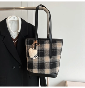 Détail du sac cabas à carreaux avec un charme en cœur et une fine bandoulière en cuir