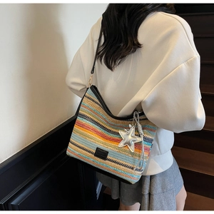 Detalle de bolso cubo tejido de colores con colgante de estrella y correa de cuero