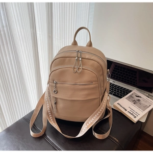 Detail of beige pebble leather backpack with silver chain zippers and wide shoulder strap