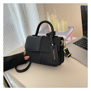 Détail d'un sac à bandoulière en cuir noir minimaliste avec ferrures dorées