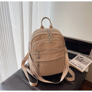 Detail of beige pebbled leather backpack with ethnic woven strap and silver zippers