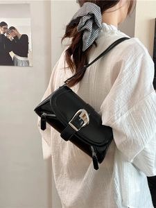 Chic black polished leather underarm bag with silver belt buckle and side zipper