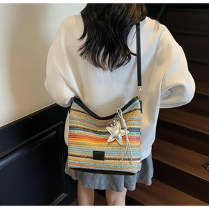 Detalle de bolso de cubo tejido en colores con rayas y colgante de estrella con borla