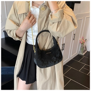 Vue détaillée du sac hobo noir avec bandoulière chaîne dorée et lettrage de mode