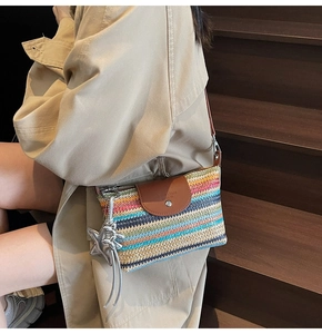 Detail der bunten gewebten Beuteltasche mit brauner Lederklappe und silbernem Sternanhänger