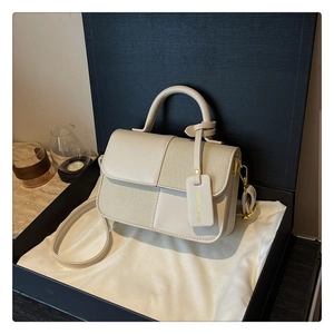 Détail du sac à main en toile et cuir dans un coffret cadeau avec étiquette mode