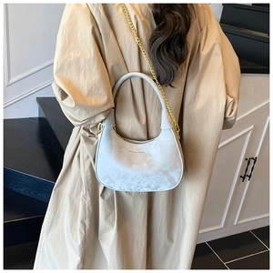 Détail du sac croissant gris clair avec texture velours et chaîne dorée pour femme