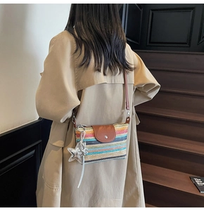 Detail der bunten geflochtenen Tasche mit Lederklappe und silbernem Sternanhänger