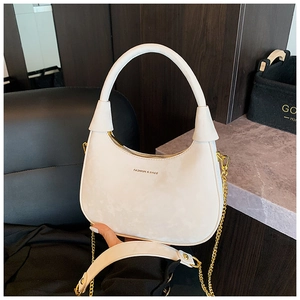 Détail du sac hobo blanc avec chaîne dorée et logo en relief sur le devant