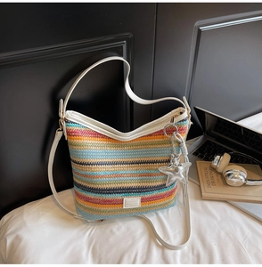 Detalle del bolso tipo cubo de tejido multicolor con colgante de estrella y correa
