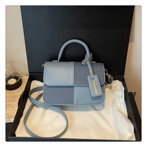 Détail du sac à bandoulière bleu bicolore avec texture tricotée en boîte cadeau