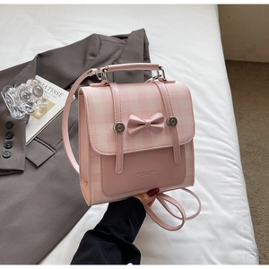 Close-up of pink plaid crossbody bag with a 3D bow and FASHION & BAGS logo text