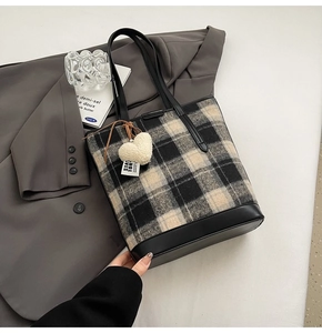 Détail du sac cabas à carreaux avec bordure en similicuir et breloque coeur blanc
